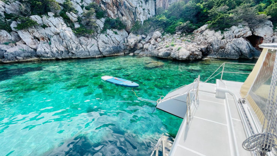 Le catamaran s'arrête dans les eaux cristallines du parc de Porto Conte.