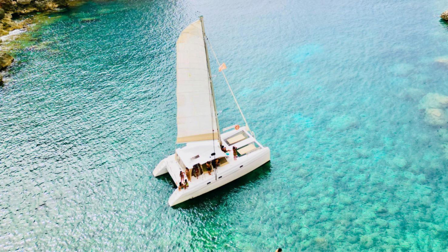 Un catamaran navigue dans la baie de Porto Conte à Alghero
