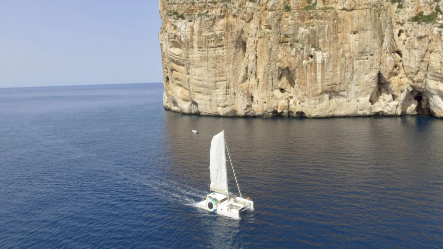 Le catamaran navigue autour des cheminées du Capo Caccia