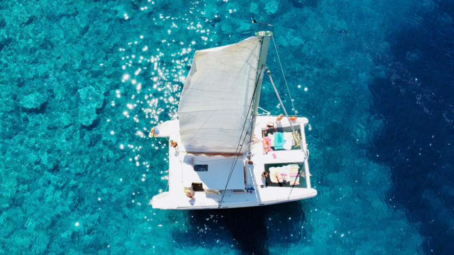 Vista sul catamarano dall'alto nell'acqua azzurra di Porto Conte