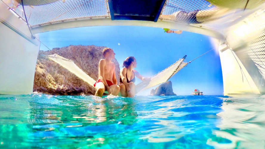 Due escursionisti si rilassano sull'amaca a poppa del catamarano