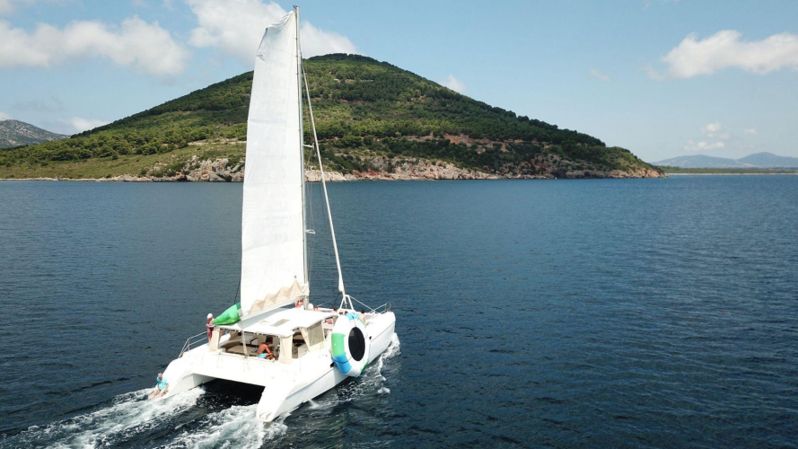 Catamarano naviga al largo della costa di Alghero