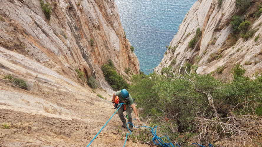 Person descending into the canal with a rope at Porto Flavia in south-west Sardinia