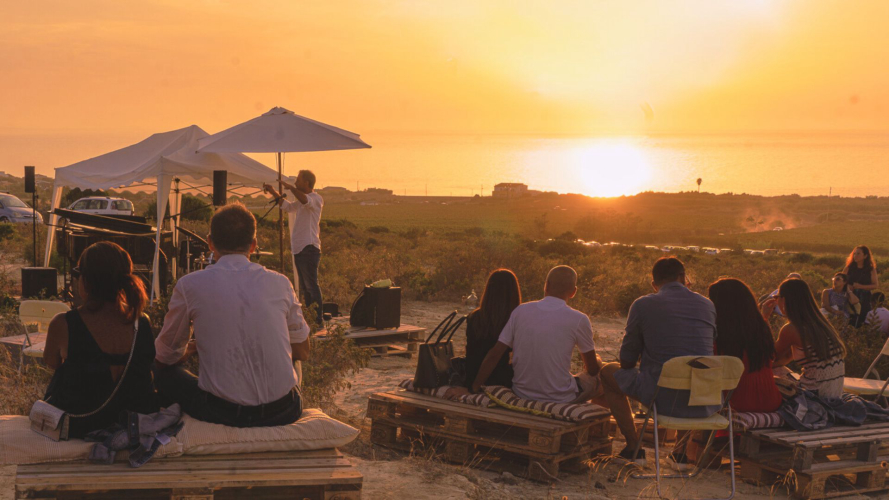 Gruppo di persone durante il picnic al tramonto nel nord-ovest della Sardegna