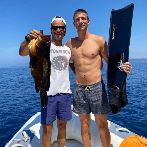 Führer mit Wanderer mit frisch gefangenem Fisch an Bord