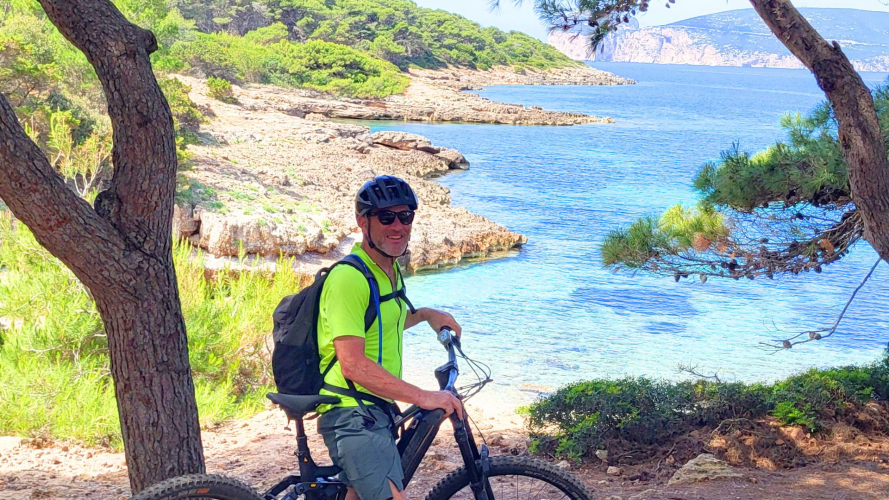 Turista en ebike con casco entre los senderos de la zona de Alghero