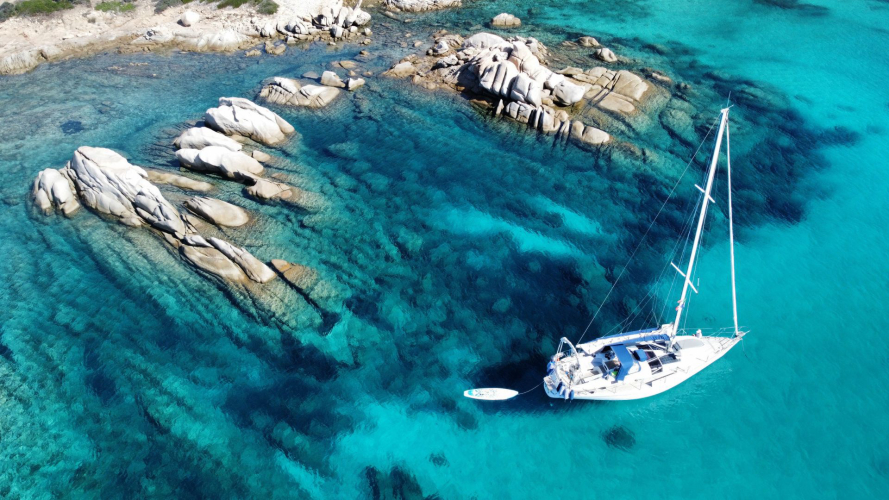 Barca a vela naviga nelle acque cristalline dell'Area Marina Protetta di Tavolara