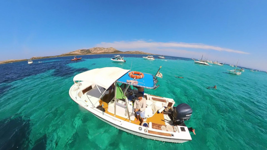 Barco a motor navegando por las aguas cristalinas de Asinara