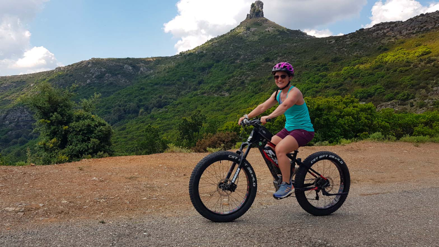 Cyclist on bike and view of Perda Liana