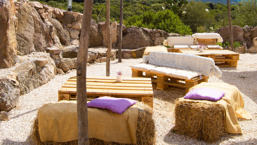 Canapés et chaises longues au bord de la piscine dans la zone de Perfugas