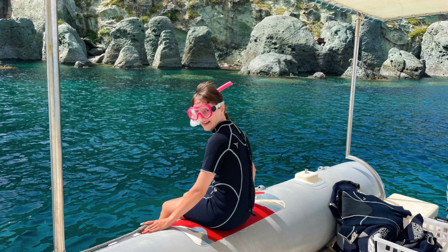 una chica se prepara para bucear en el mar cristalino de Capo Marrargiu