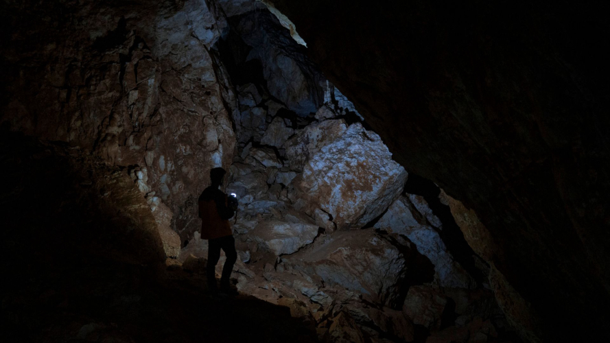 Wanderer wandert in der dunklen Höhle Sa Nurre de Su Hoda in Oliena