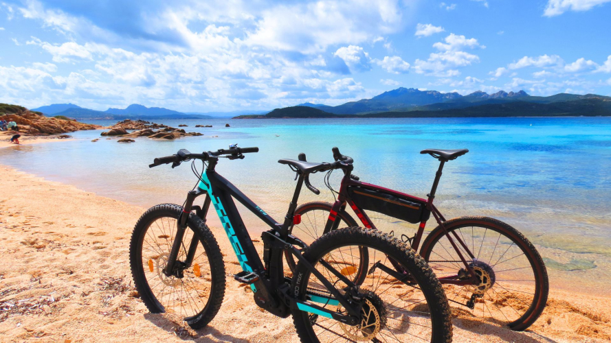 Two electric bikes at a beach on the Emerald Coast