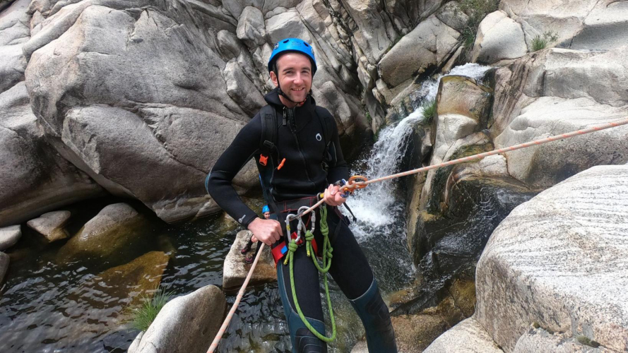 Boy rappels while canyoning in Bau Mela