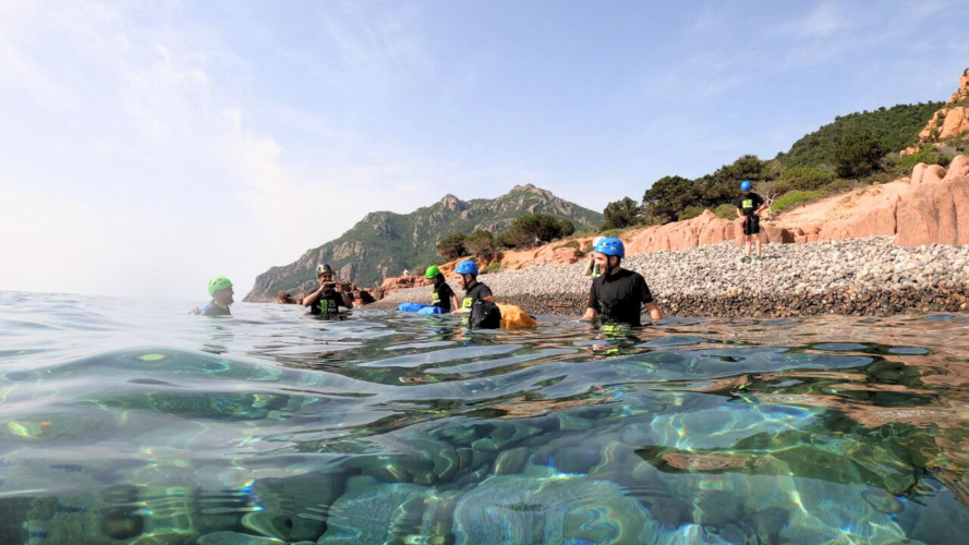 Hikers with guide and equipment in the sea of the Gulf of Orosei