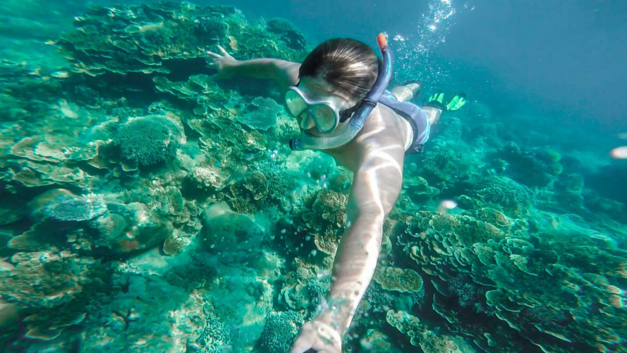 Niño buceando en las aguas azules del Golfo de Orosei