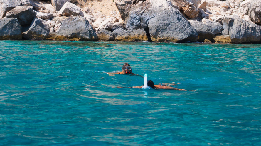 Zwei Personen beim Schnorcheln im azurblauen Wasser des Golfs von Orosei