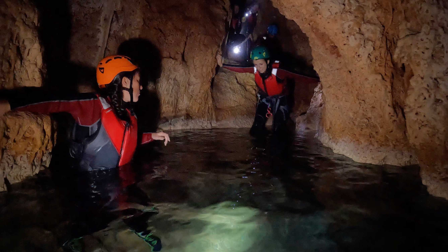 Hikers inside a cave in the coast of Porto Conte