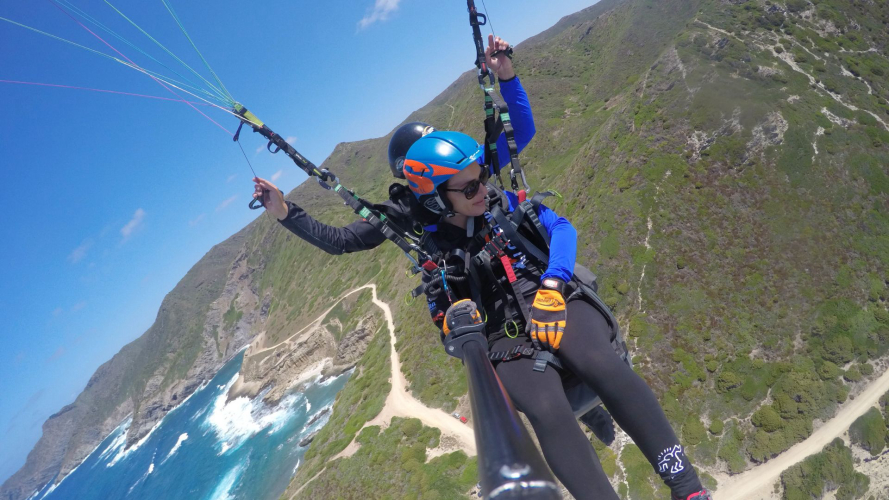 A girl performs a paragliding flight from Littigheddu