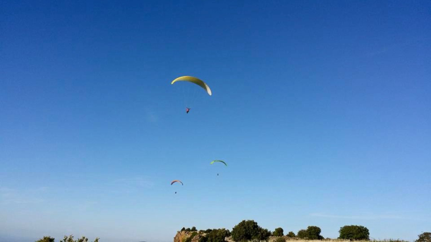 Hikers fly paragliders with experienced instructors