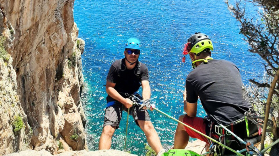 Ragazzo durante calata in corda con guida e attrezzatura