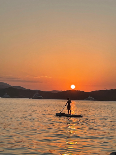 chica en una excursión de SUP al atardecer en el mar de la Costa Esmeralda