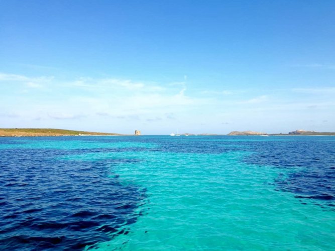 Blaues Wasser im Golf von Asinara mit einem Türmchen am Horizont
