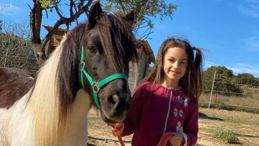Bambina con un pony in una fattoria del sud della Sardegna