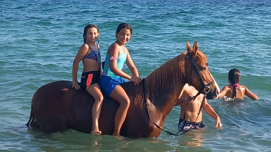 Mädchen baden zusammen mit dem Pferd im Süden Sardiniens