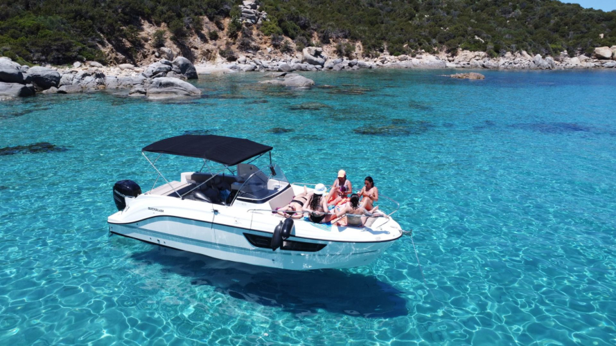 Barca a motore naviga nelle acque cristalline di Villasimius