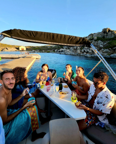Persone fanno l'aperitivo durante il tour in barca al tramonto a Villasimius