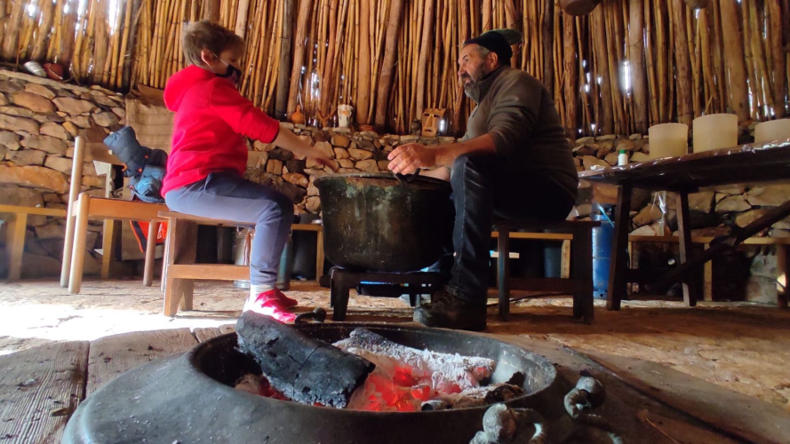 Shepherd and boy during cheese and ricotta workshop on a farm in north-western Sardinia