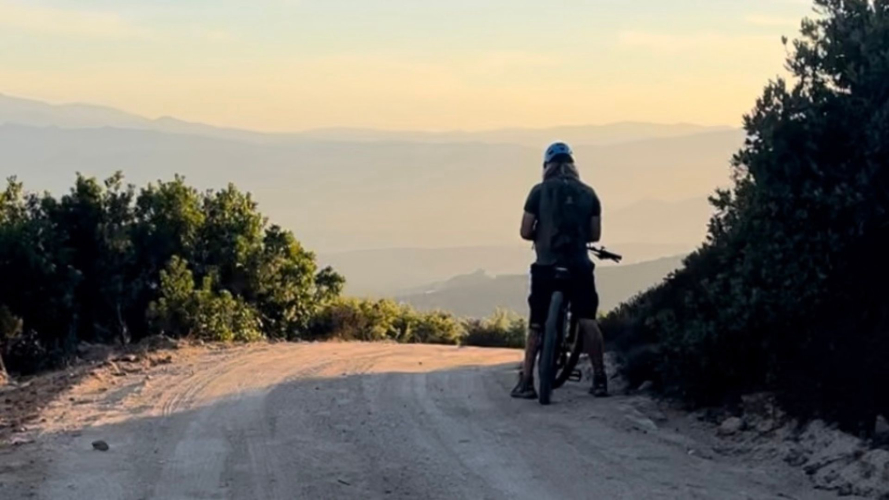 Escursionista sosta durante l'escursione in e-bike a Monte Moro al tramonto