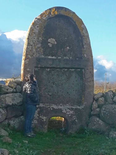 Girl observes entrance to tomb of the giants in Borore