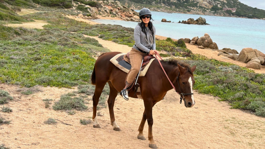 Mädchen reitet auf einem Pferd während einer Tour durch La Maddalena
