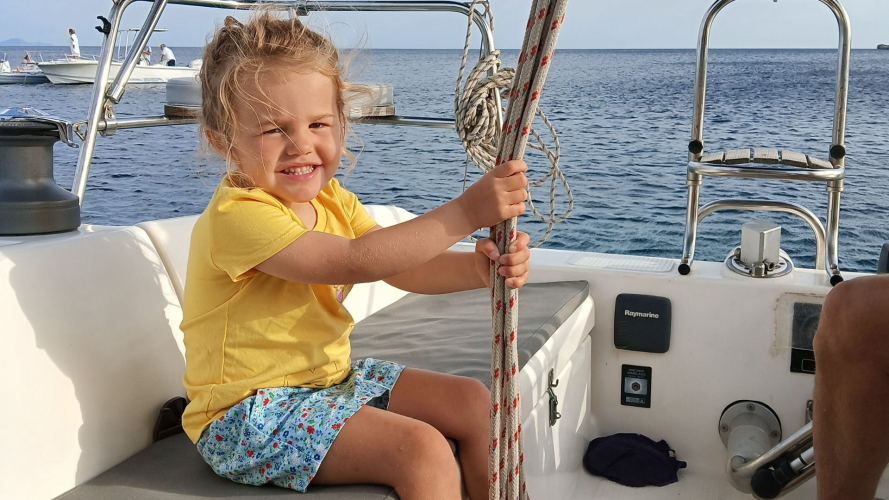 Bambina felice durante il tour in barca a vela ad Alghero