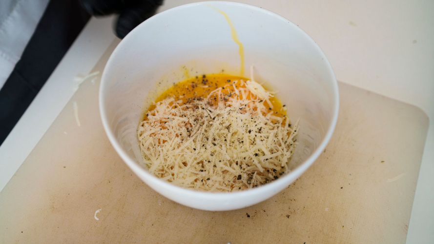 Preparazione del condimento con uova, pecorino e pepe durante la lezione sulla pasta alla carbonara