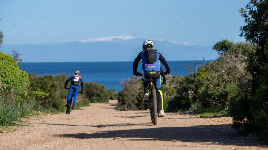 Deux garçons pédalent pendant l'excursion en canot pneumatique et en vélo électrique à La Maddalena et Caprera.