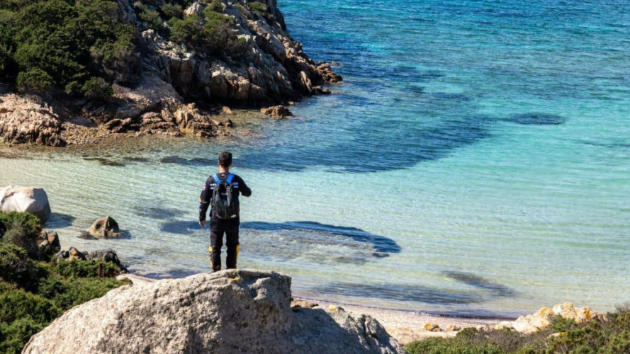 Un participant à une excursion en vélo électrique observe les eaux bleues de l'archipel de La Maddalena.