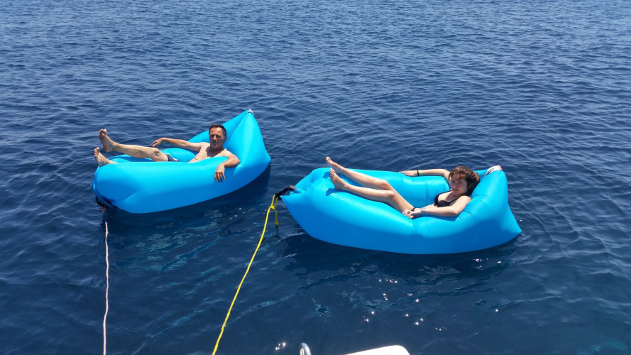 Due persone nei materassini gonfiabili nel mare di Alghero