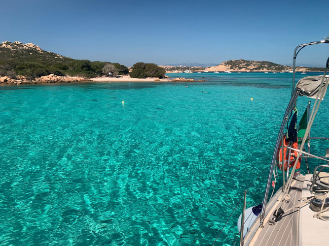 Barca a vela nel mare cristallino nell'Arcipelago della Corsica tra Lavezzi e isola Piana