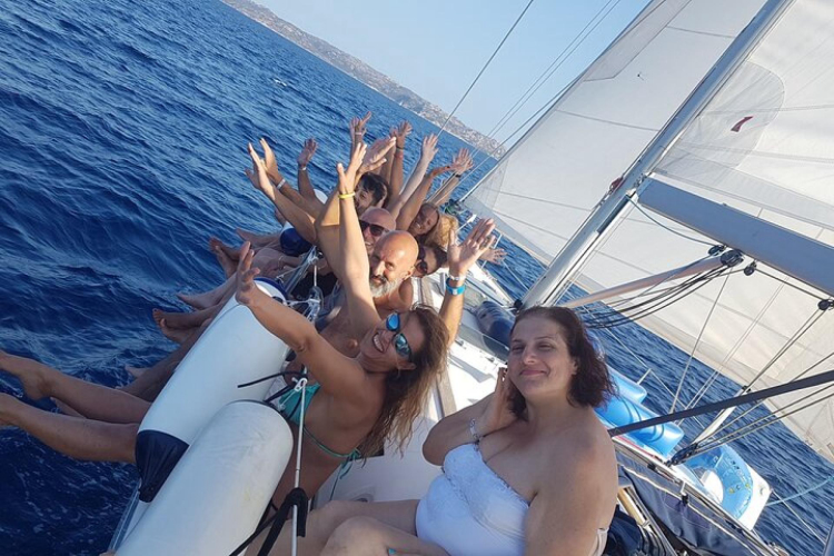 Personas a bordo del velero mientras navega por las aguas cristalinas del área marina protegida de Tavolara