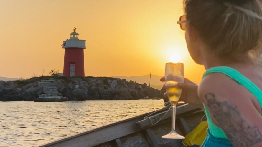 Velero vintage frente a la costa de Alghero al atardecer