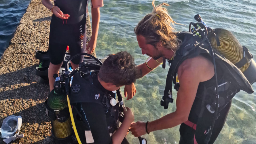 Junge bereitet sich auf das Tauchen im Sommer auf Sardinien vor