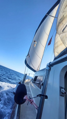 Barca a vela mentre naviga nelle acque cristalline di Stintino