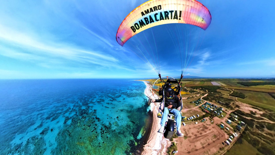 Powered paragliders fly over the coast of Cabras, Sardinia