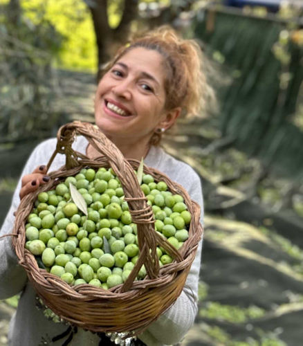 Señora muestra aceitunas en cesta
