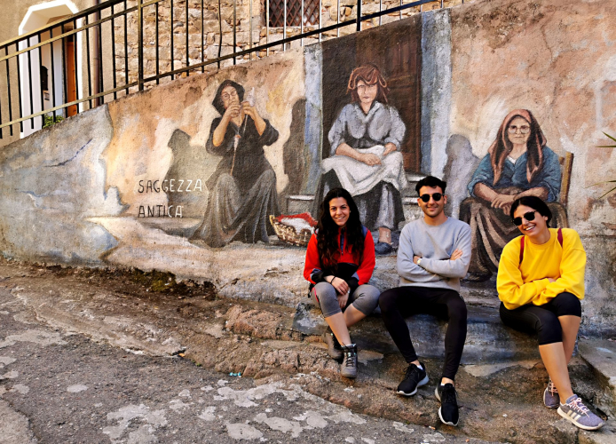 Randonneurs avec les peintures murales d'Orgosolo en arrière-plan lors d'une visite guidée