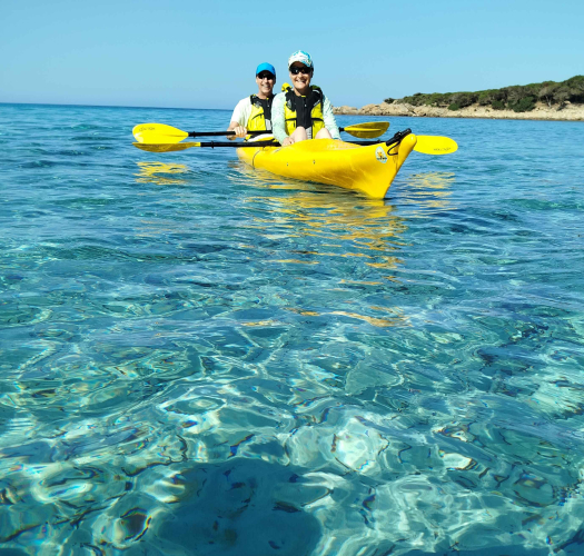 Senderistas navegan en kayak por las aguas vírgenes entre Chía y Tuerredda