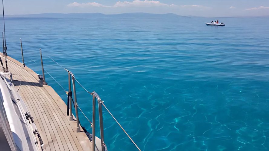 Segelboot im türkisfarbenen Meer während einer Tour im Golf von Cagliari